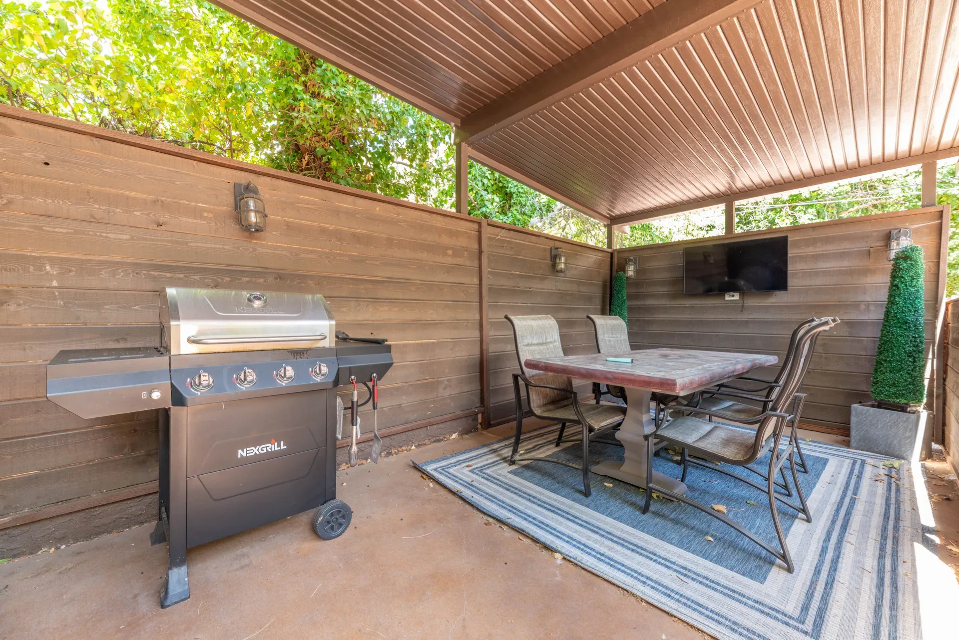 Covered pergola dining area with barbecue and TV