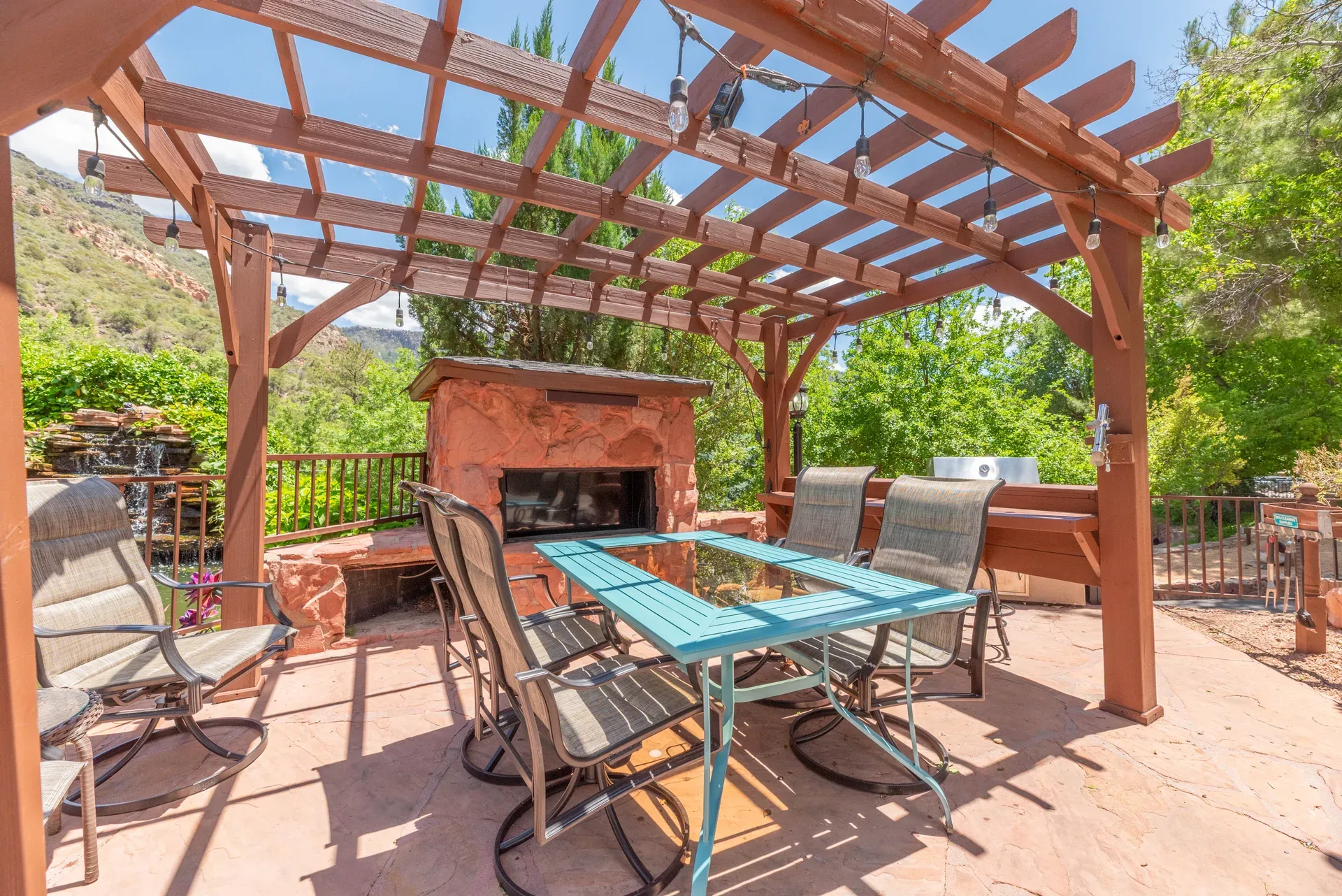 Outdoor pergola terrace with stone fireplace