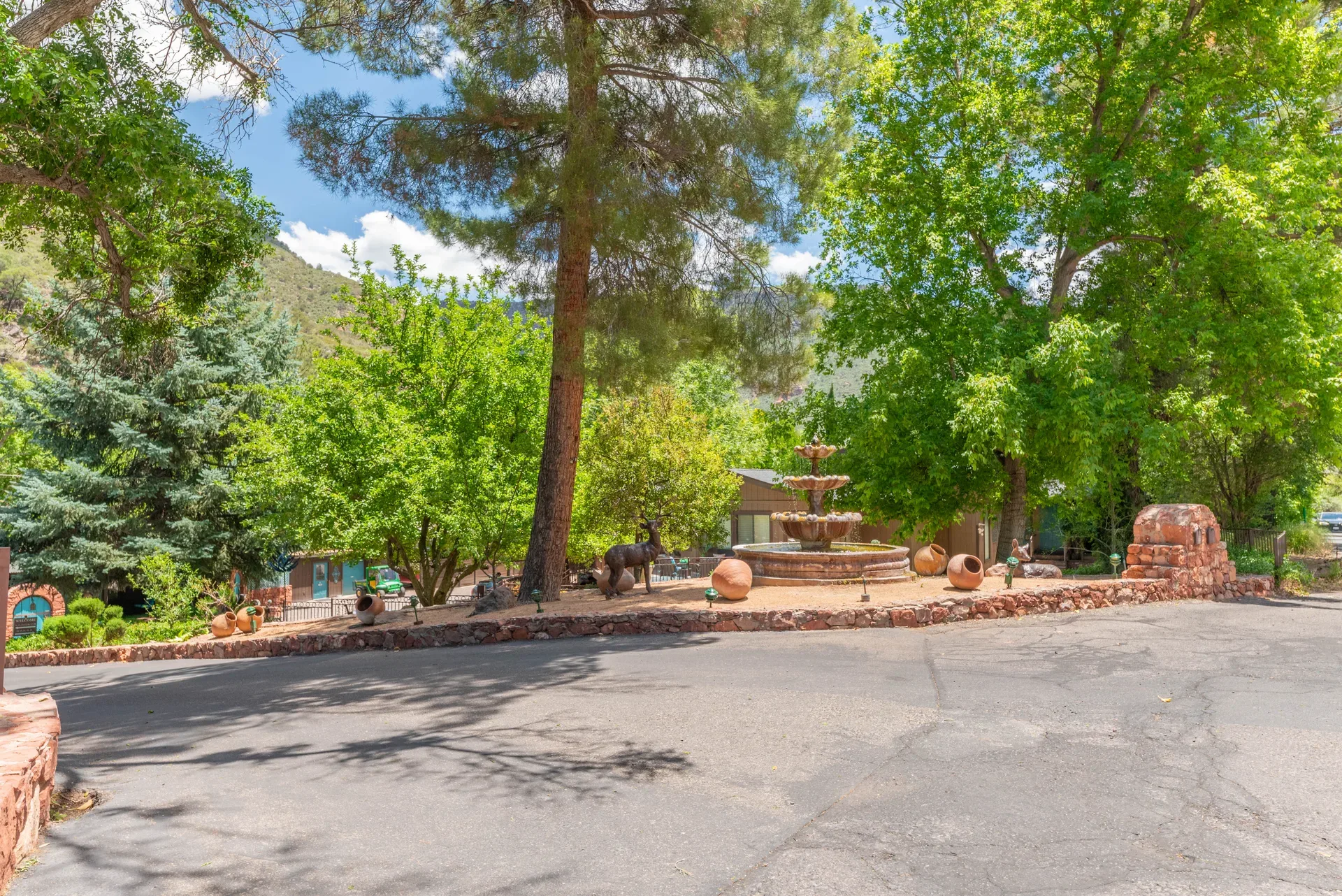 Central stone tiered fountain surrounded by mature trees