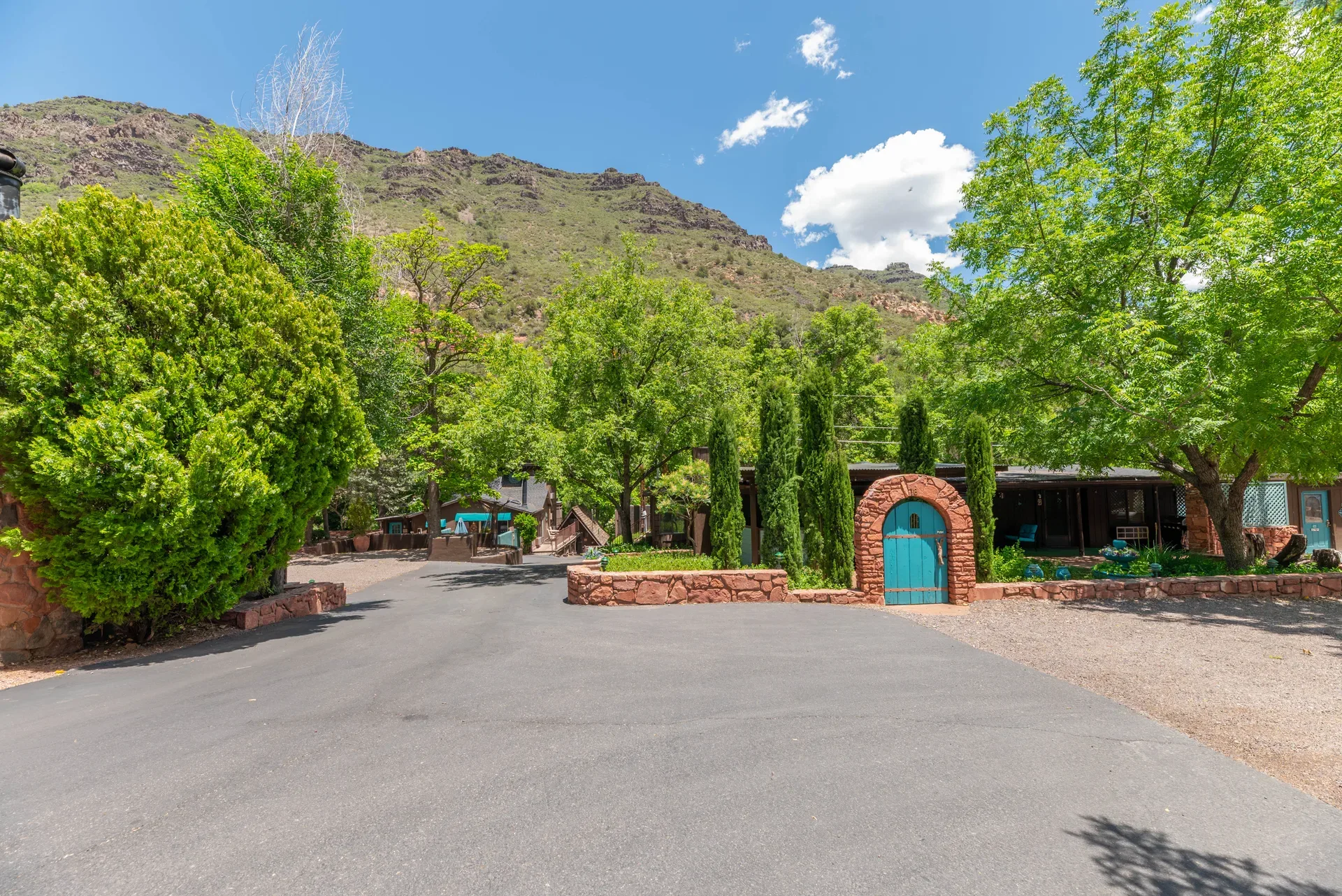Oak Creek Terrace Resort grounds entrance with arched turquoise gate and red rock canyon backdrop