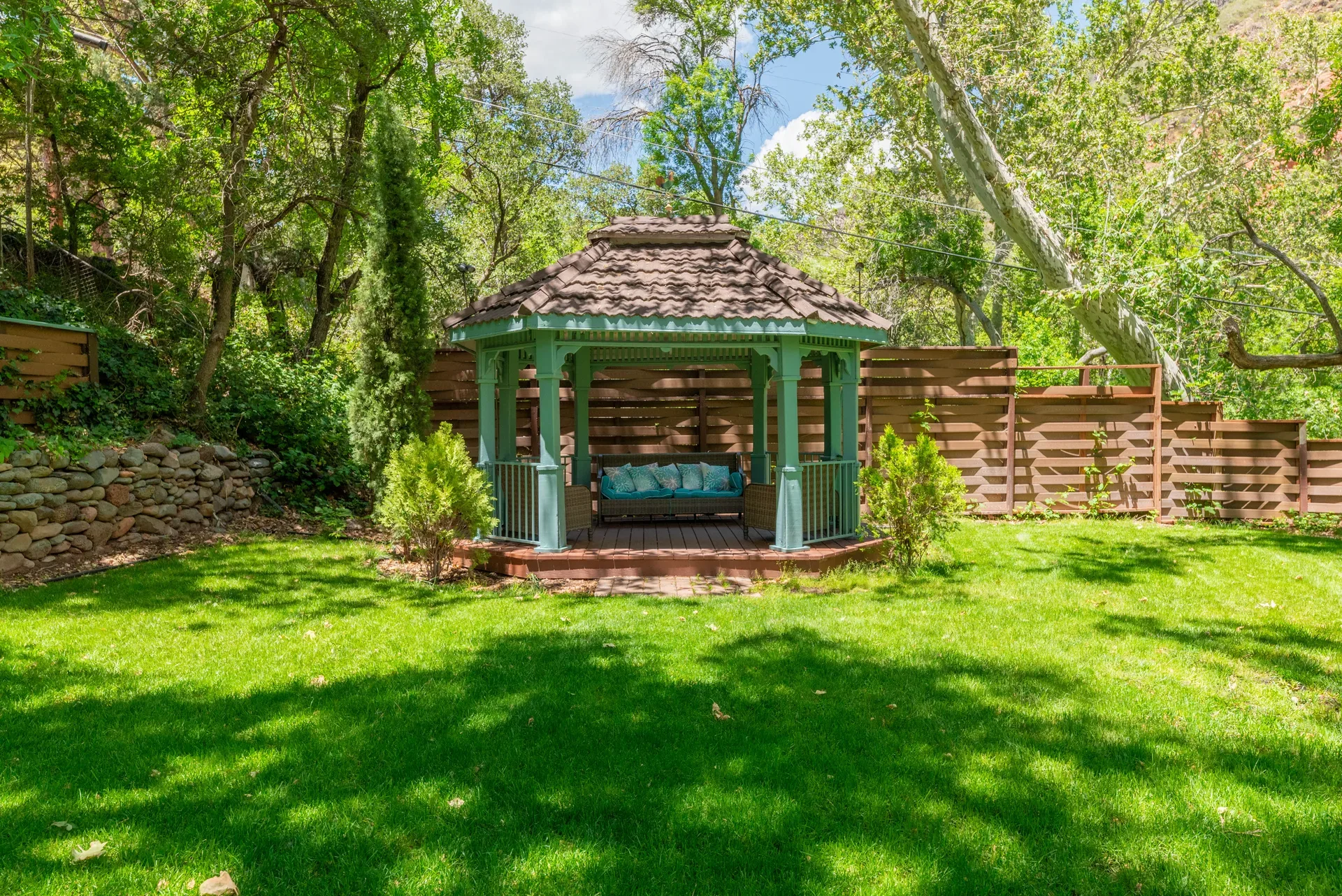 Garden gazebo with bench seating on lush lawn