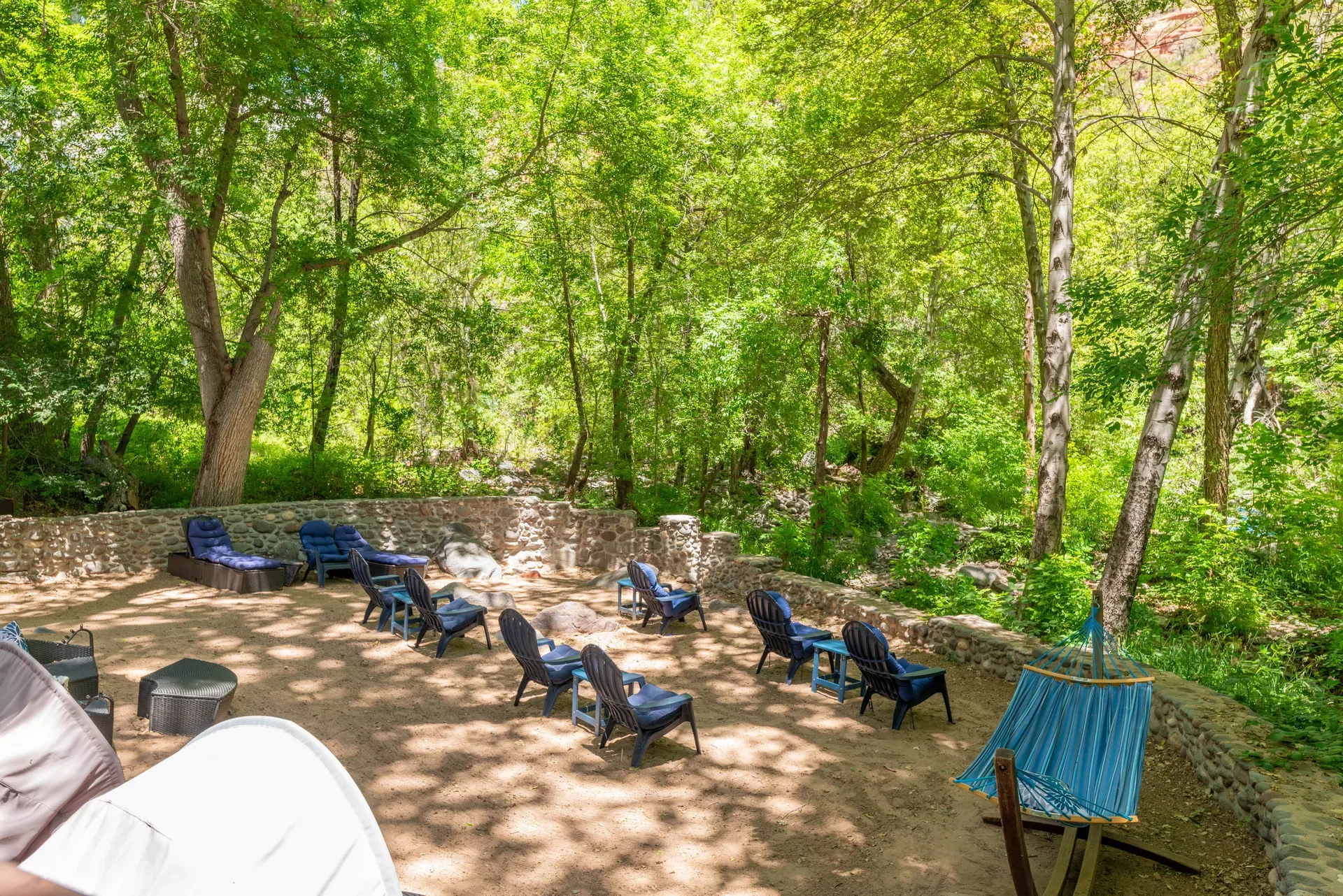 Creekside gathering area with lounge chairs and hammock