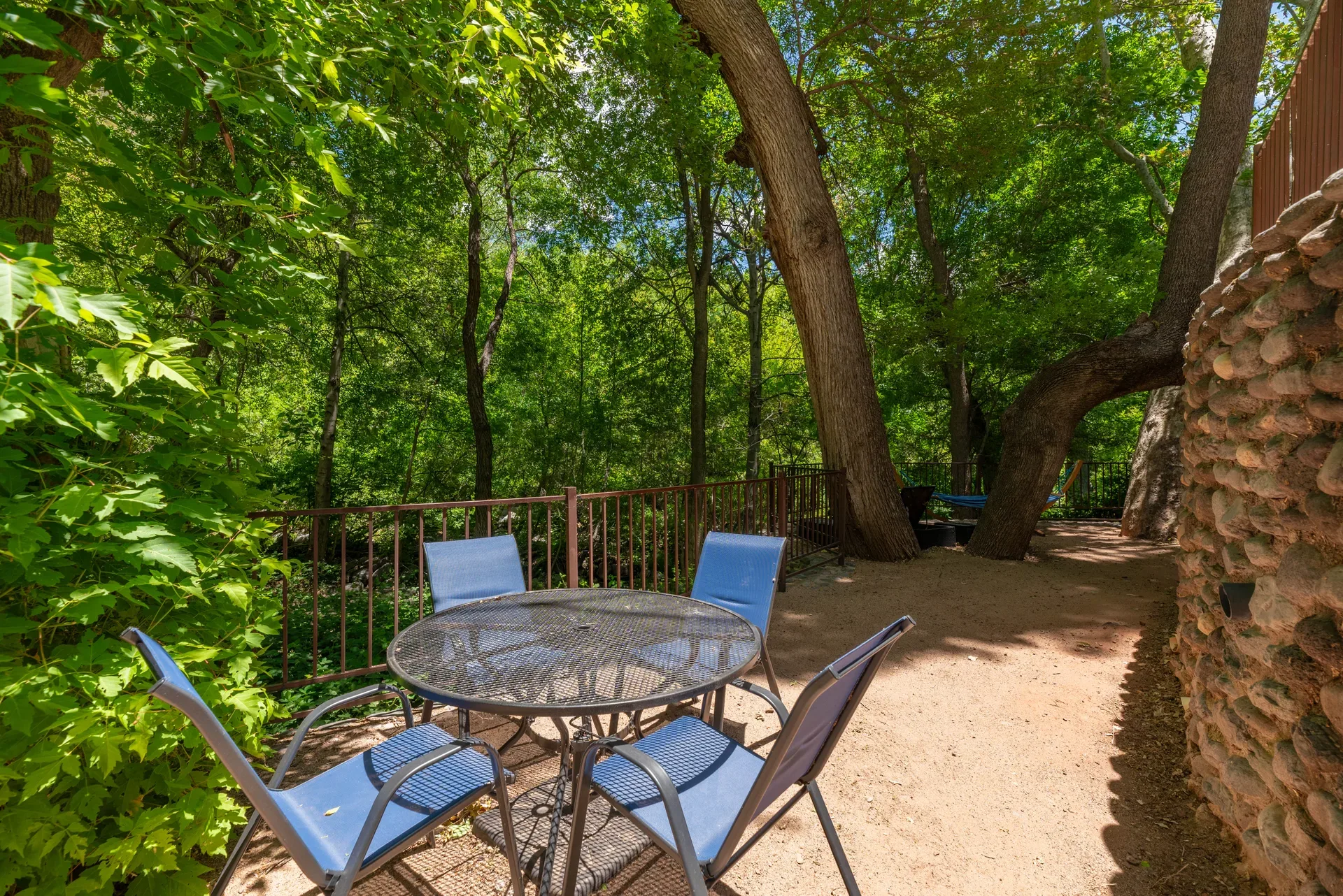 Creekside patio with metal table and blue chairs