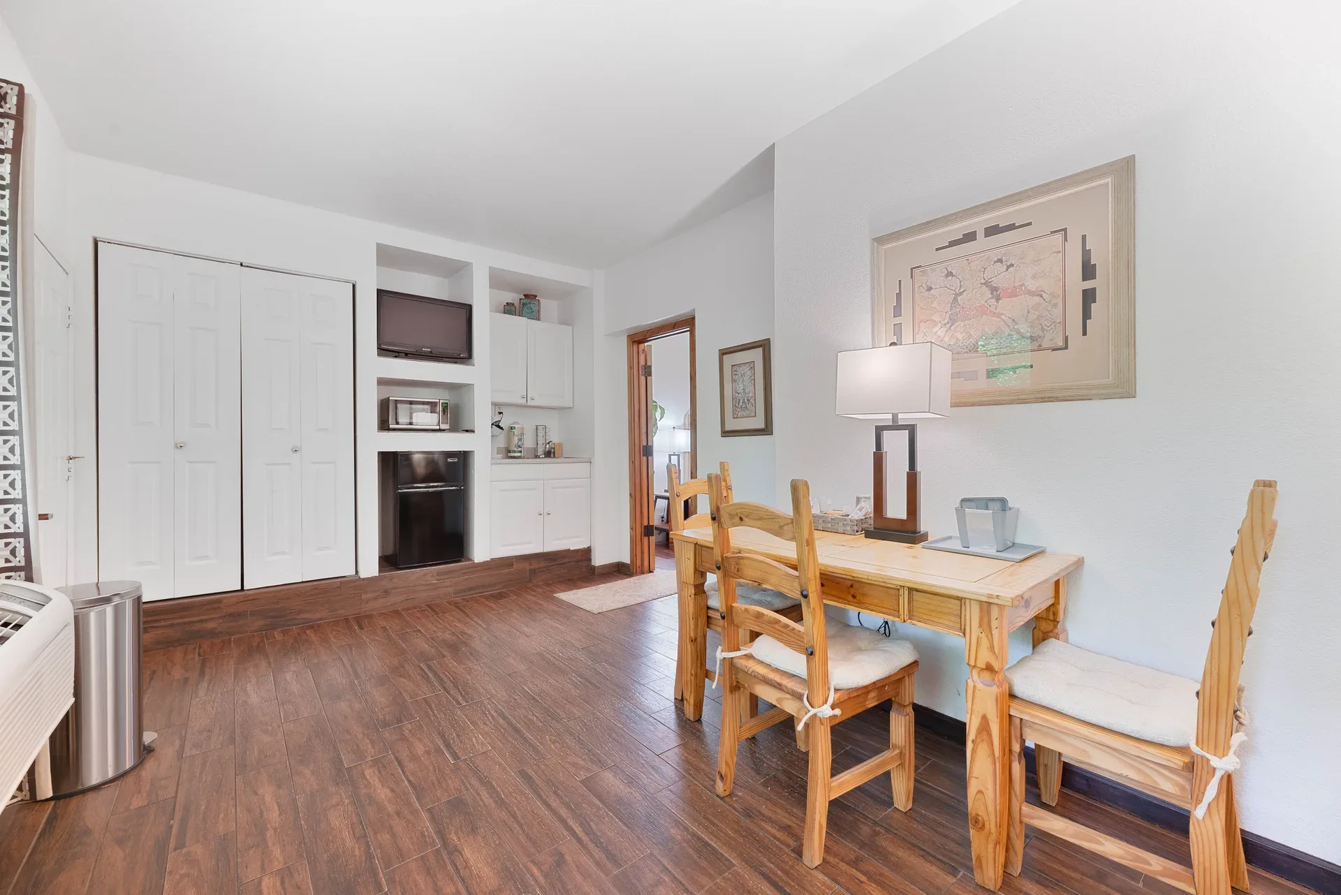 Guest room with wood-look tile flooring and built-in cabinetry