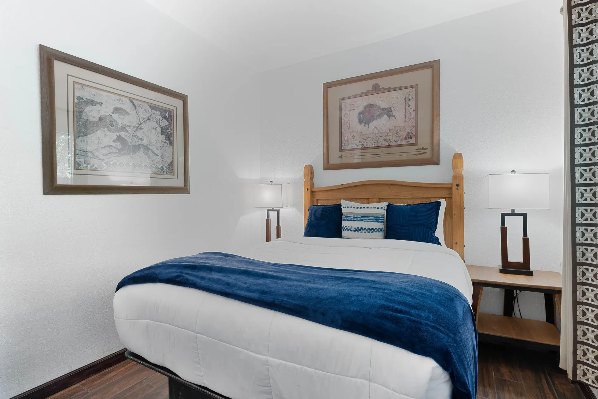 Guest bedroom with warm wood frame bed and patterned curtains