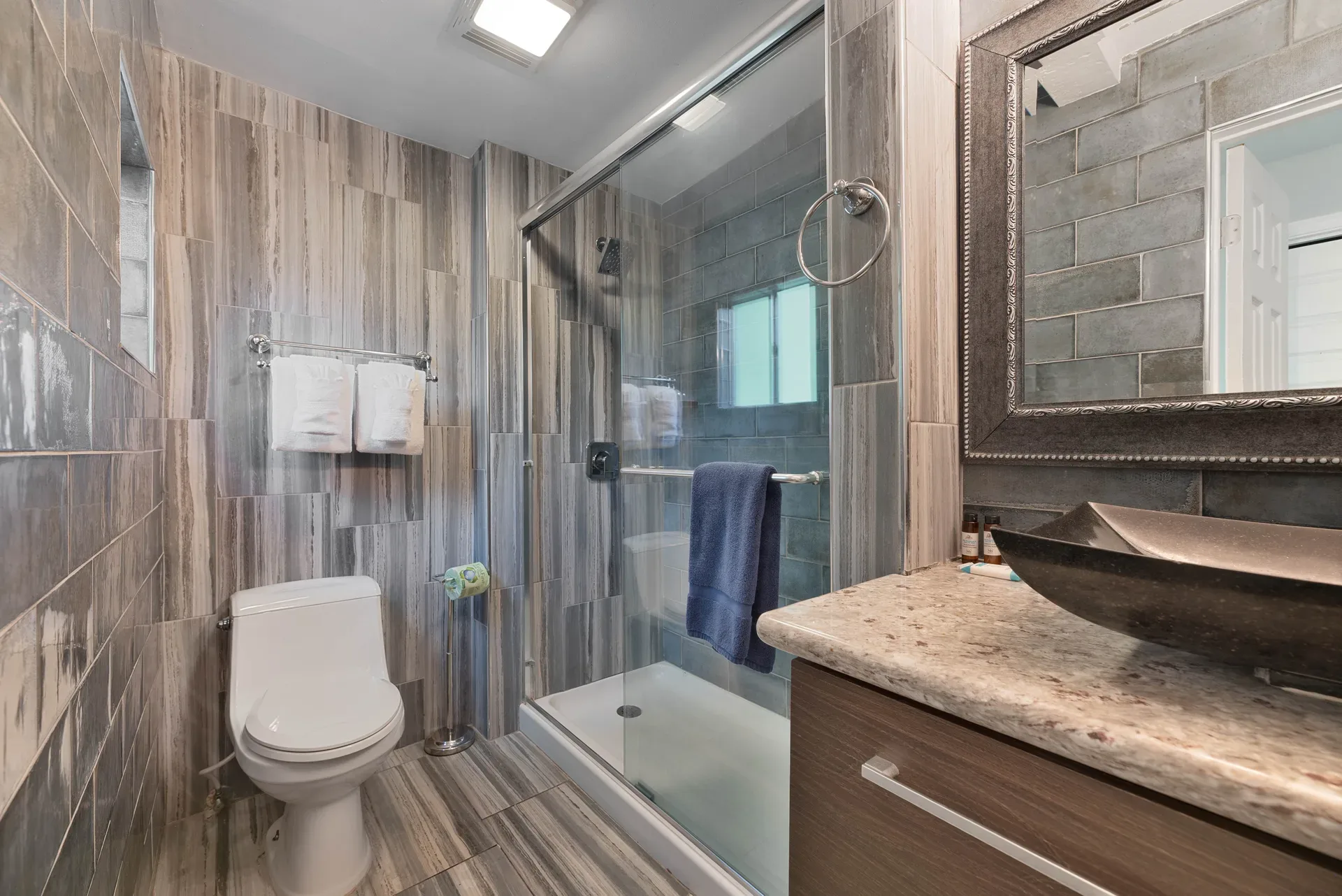 Modern rustic bathroom with wood-grain tile and vessel sink