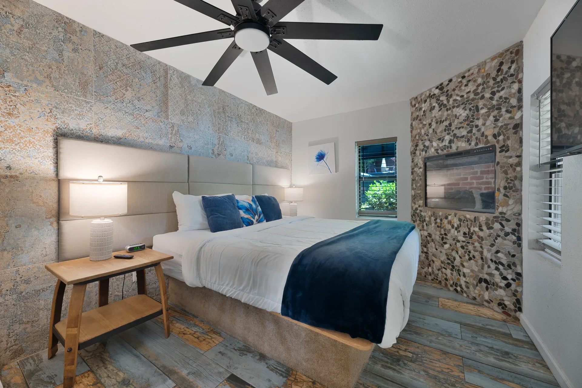 Boutique hotel suite with stone accent wall and electric fireplace