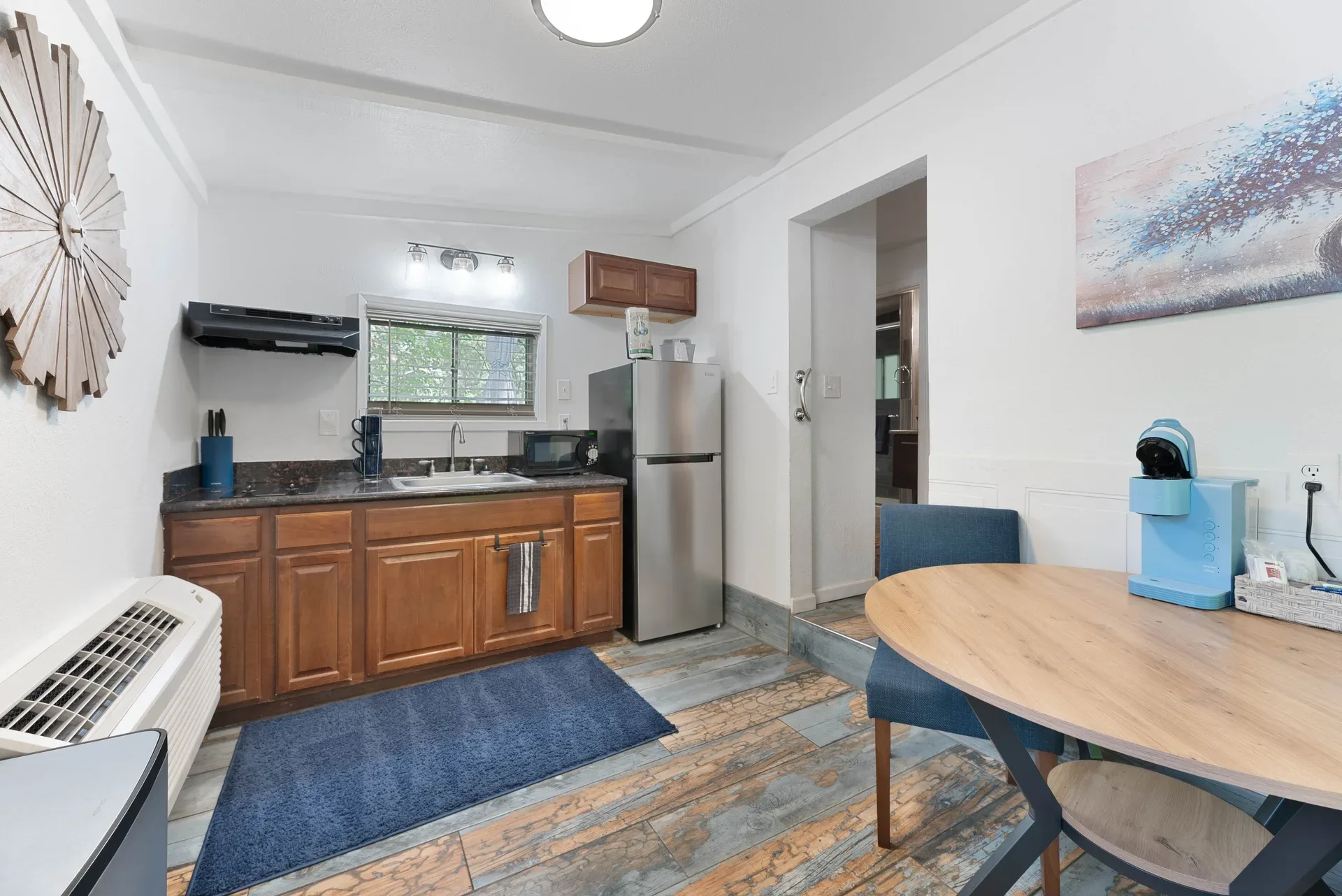 Compact resort kitchenette with wood cabinetry and stainless fridge