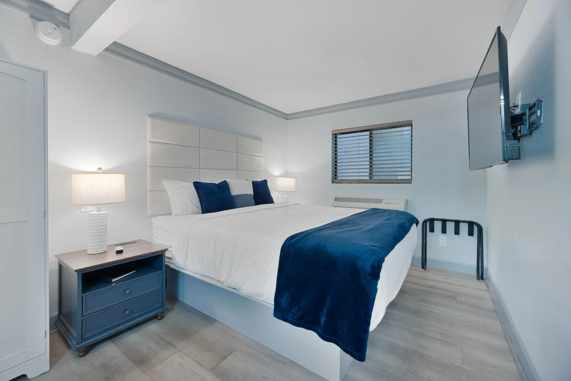 Contemporary hotel room with king bed and blue accents