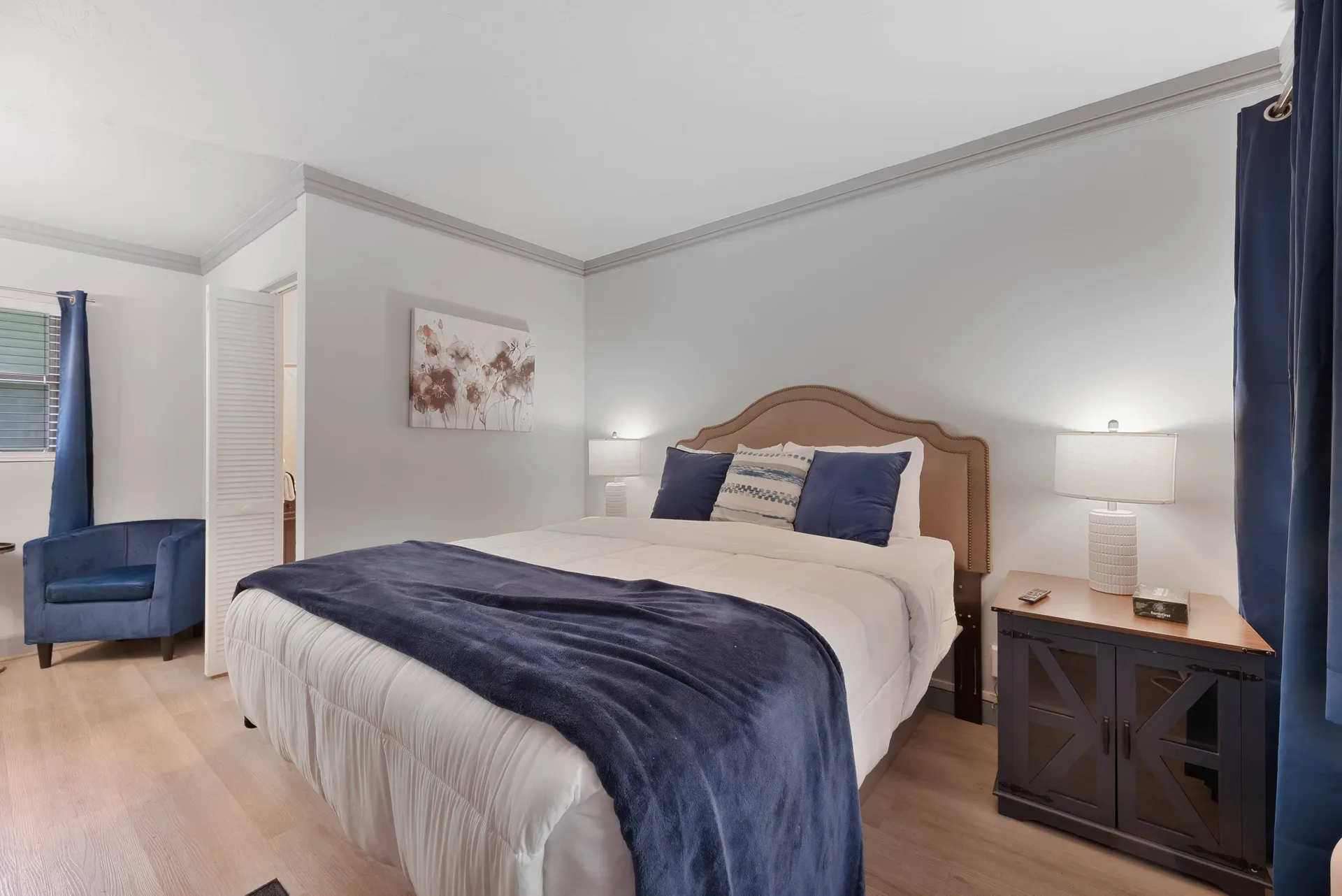 Boutique resort bedroom with king bed and blue armchair