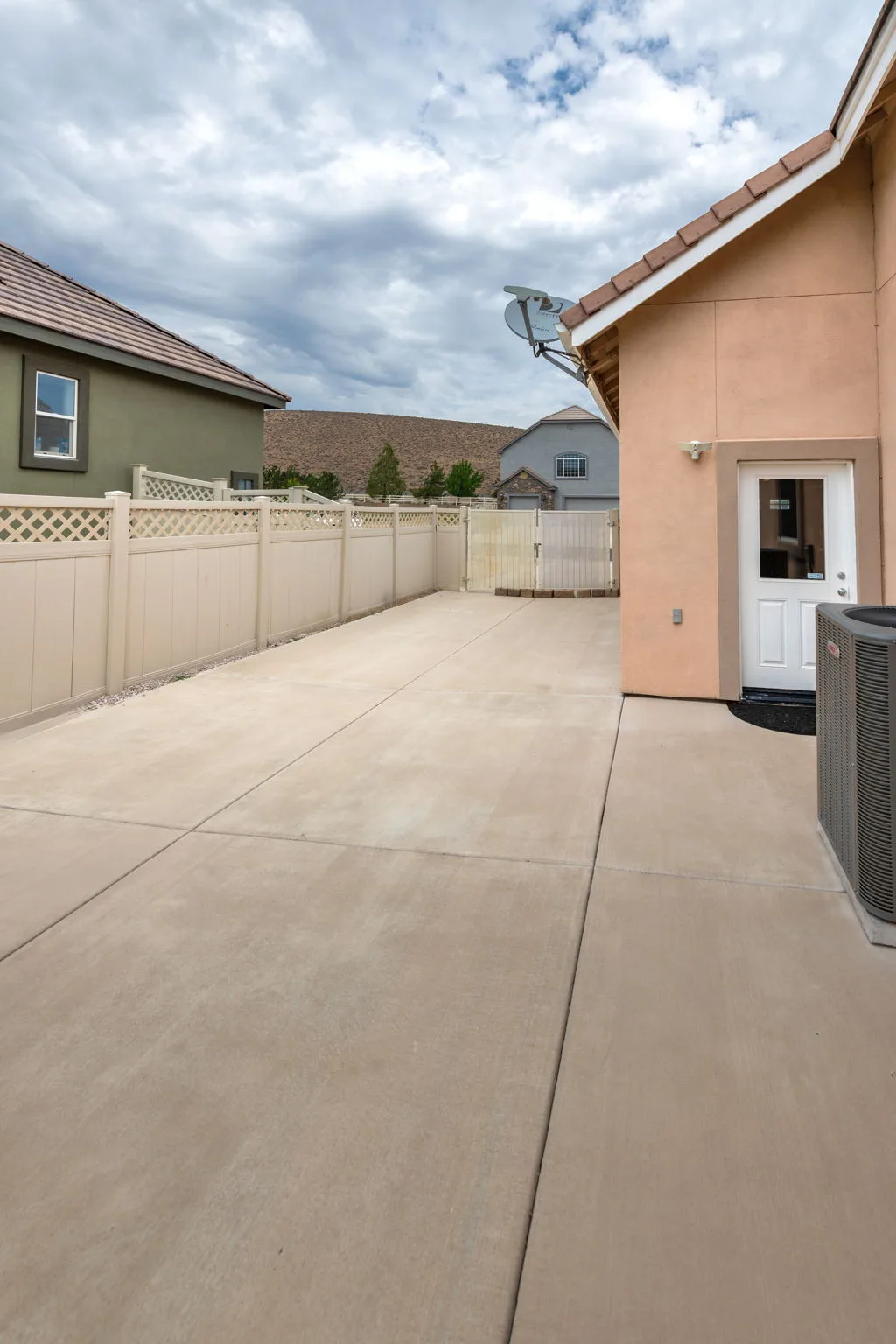 Side yard with concrete path and vinyl fencing
