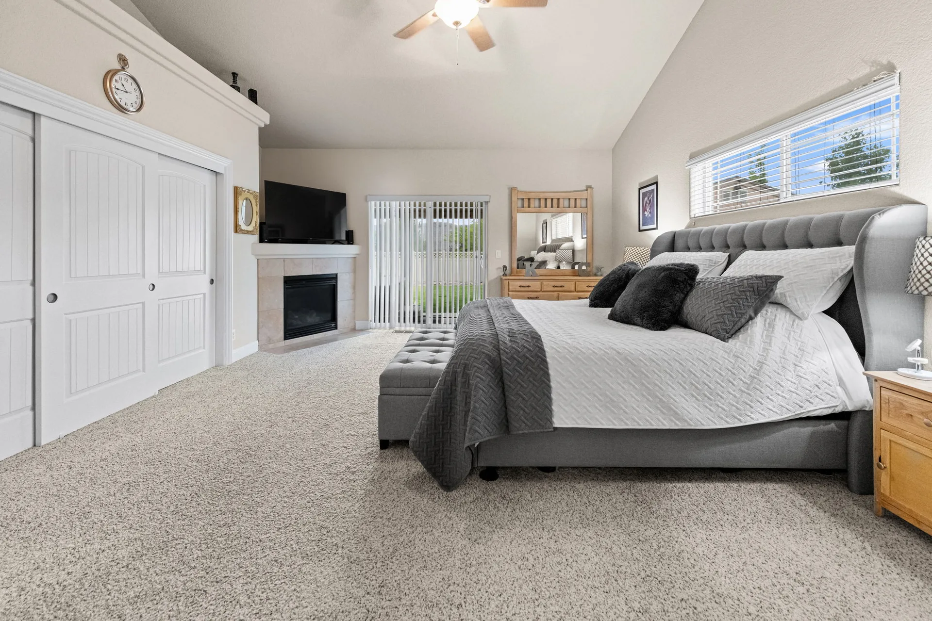 Primary bedroom with fireplace and vaulted ceilings