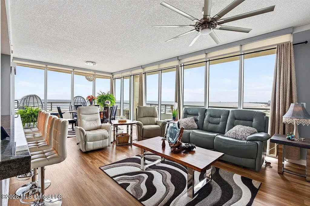 Open living and dining area with floor-to-ceiling Gulf views