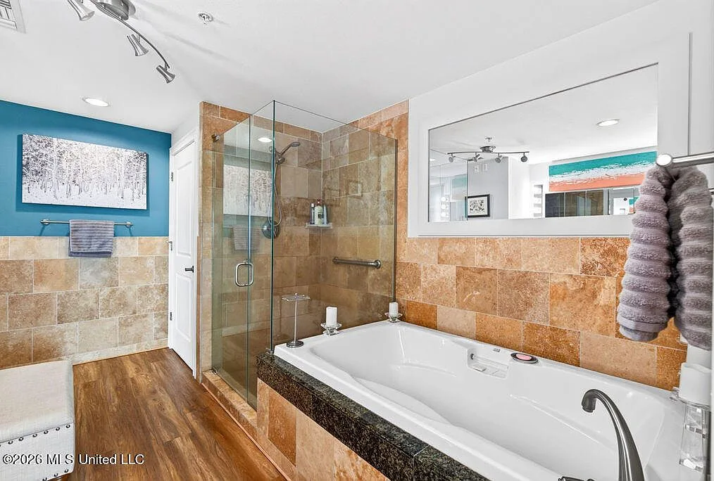 Primary bathroom with soaking tub and teal accent wall