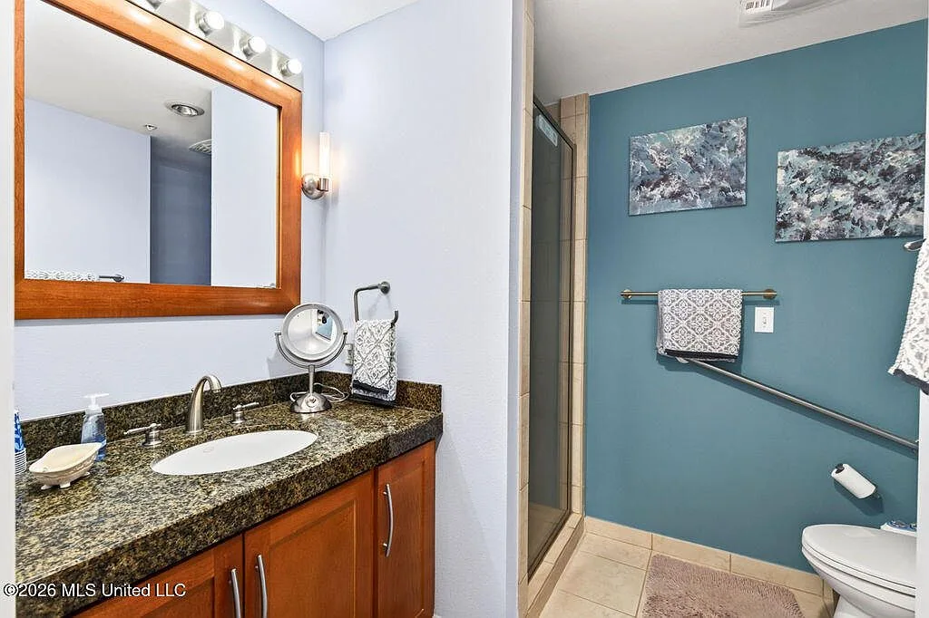 Guest bathroom with blue accent wall and dark granite vanity