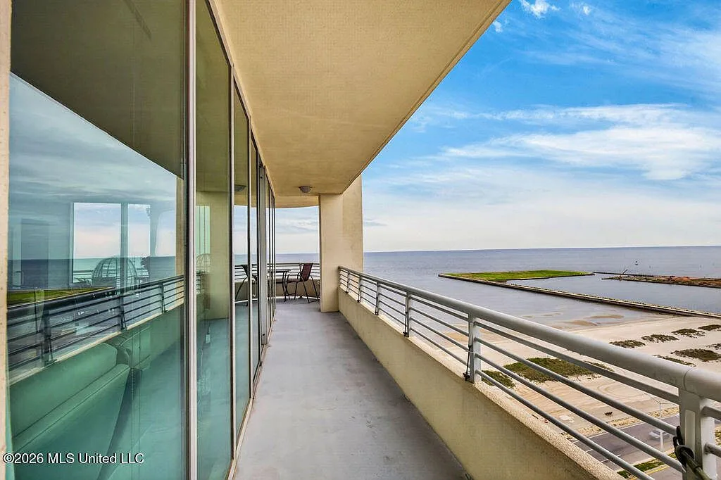 Balcony with floor-to-ceiling windows and coastal views