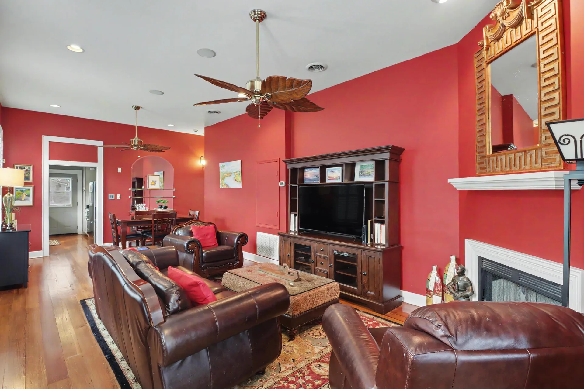 Wide-angle living room with leather furniture, high ceilings, and heart pine floors