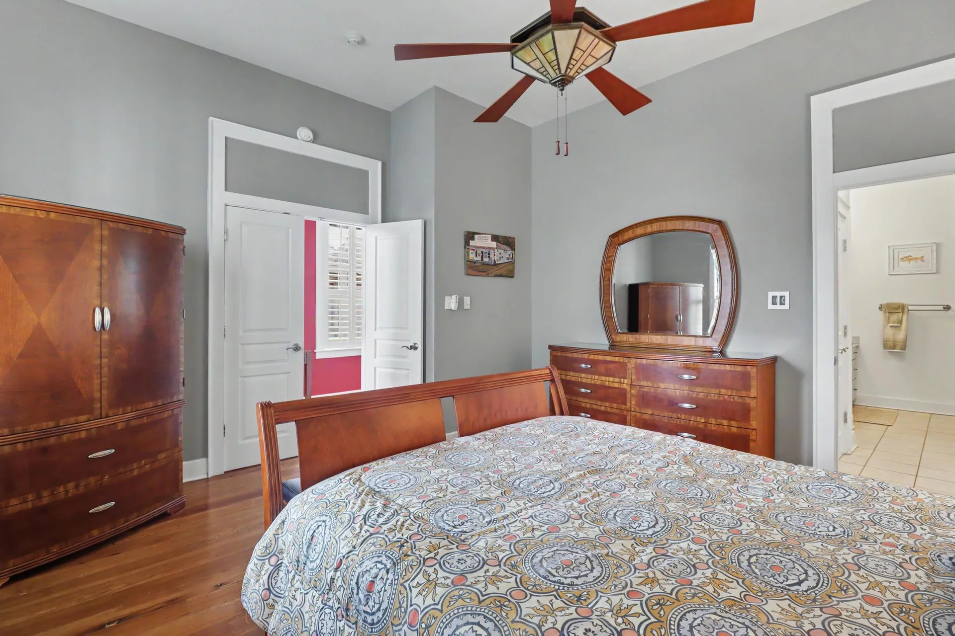 Bedroom with gray walls, heart pine floors, and transom doors