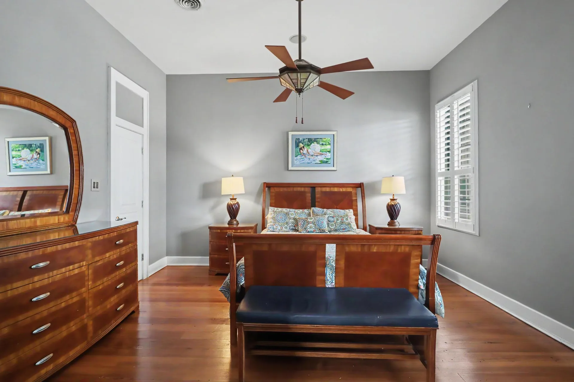 Master bedroom with heart pine floors, grey walls, and king-size bed frame