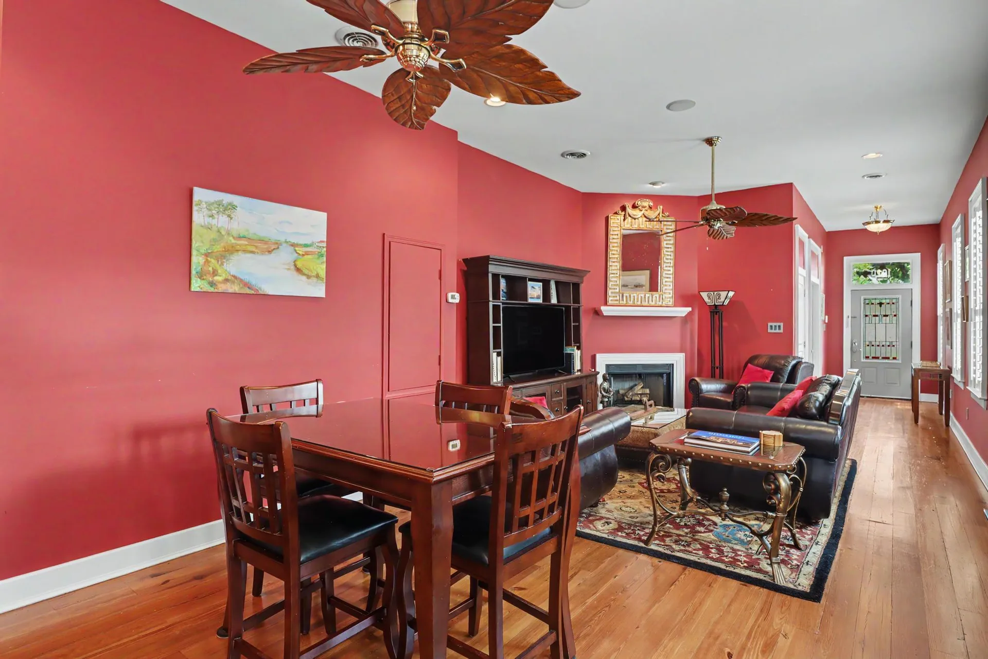 Open-concept living and dining area with red walls and heart pine hardwood floors