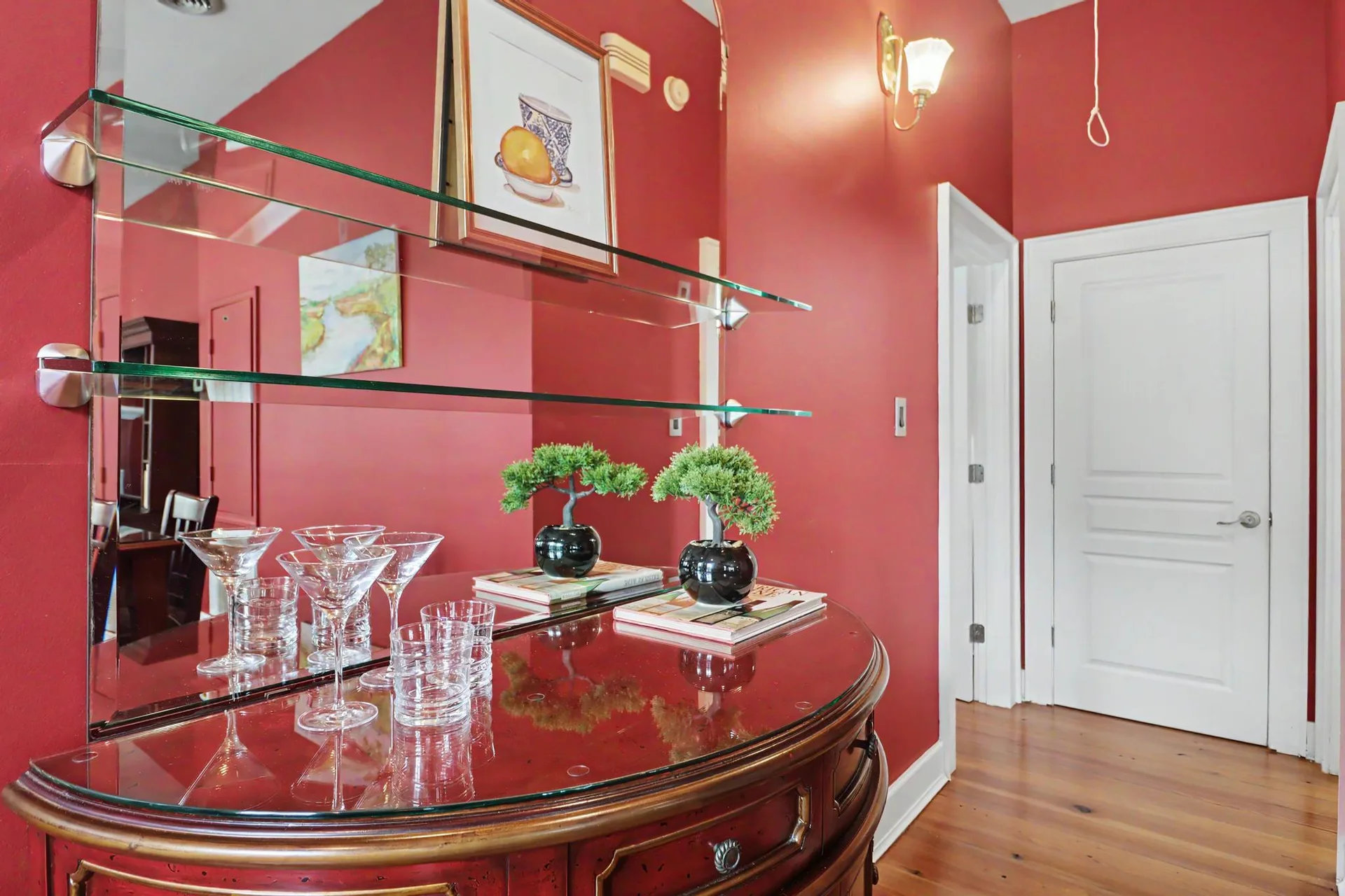 The hallway at 1620 2nd Street with red walls, wall shelving, a mirror, and heart pine floors