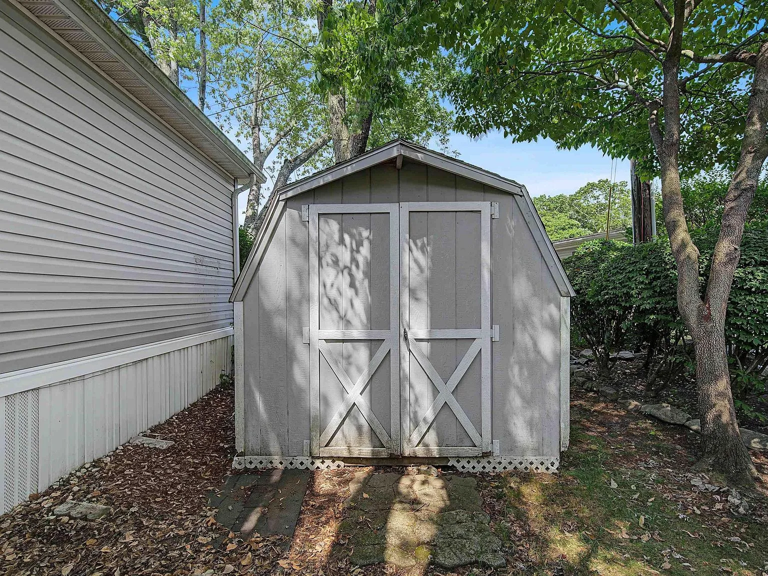 Backyard wooden storage shed adjacent to the home