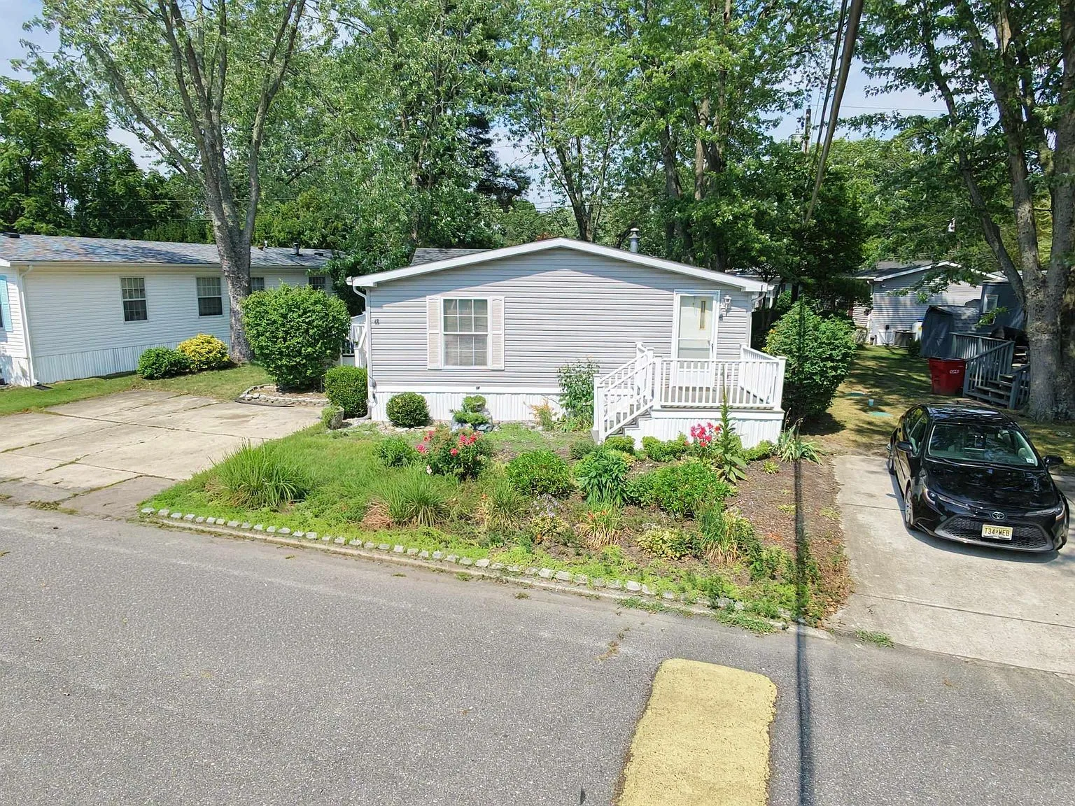 Front facade showing driveway, porch, and flowering plants