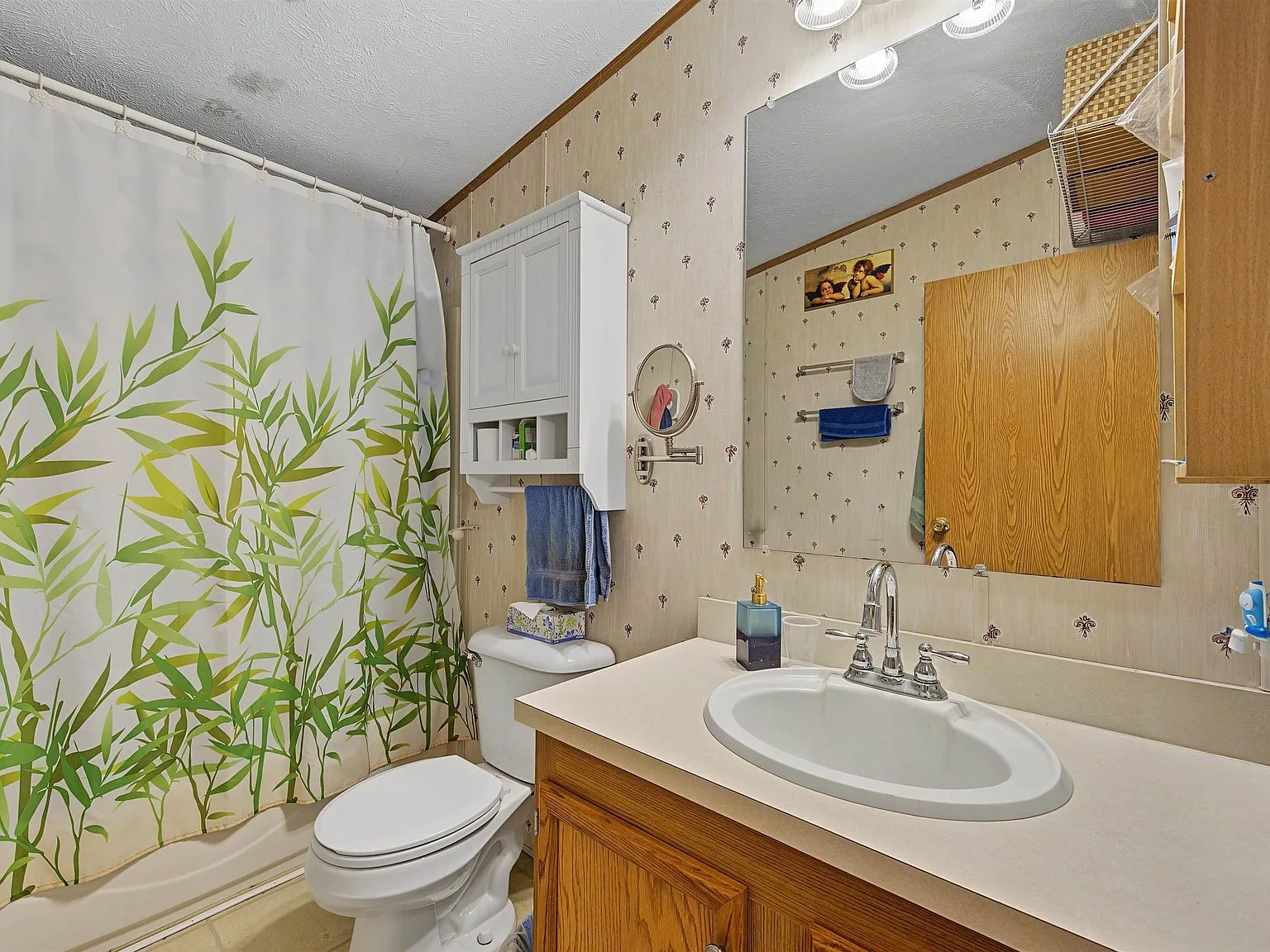 Second bathroom with oak vanity and patterned wallpaper