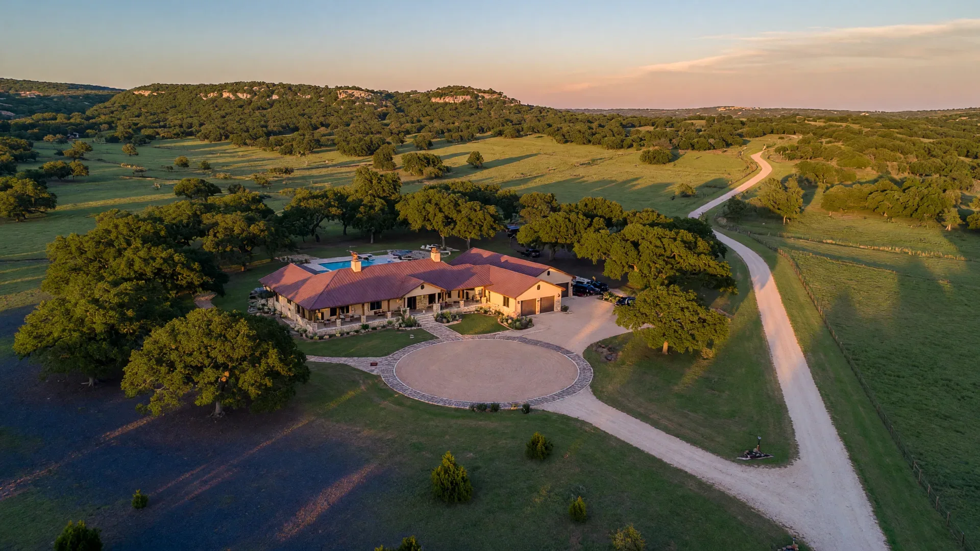 Aerial view of Texas Hill Country custom home on acreage with oak trees