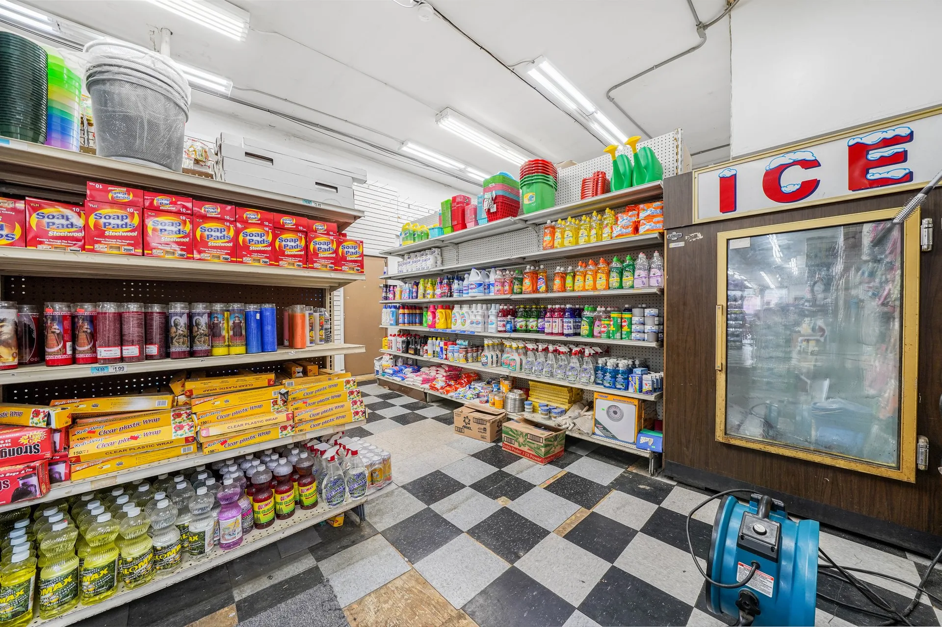 Aisle view with floor-to-to-shelving loaded with household and grocery products