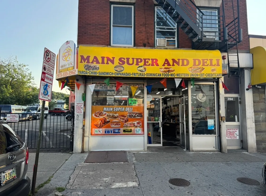 Exterior storefront of Main Super and Deli at 394 Main Street, Paterson, NJ showing the yellow awning and glass front