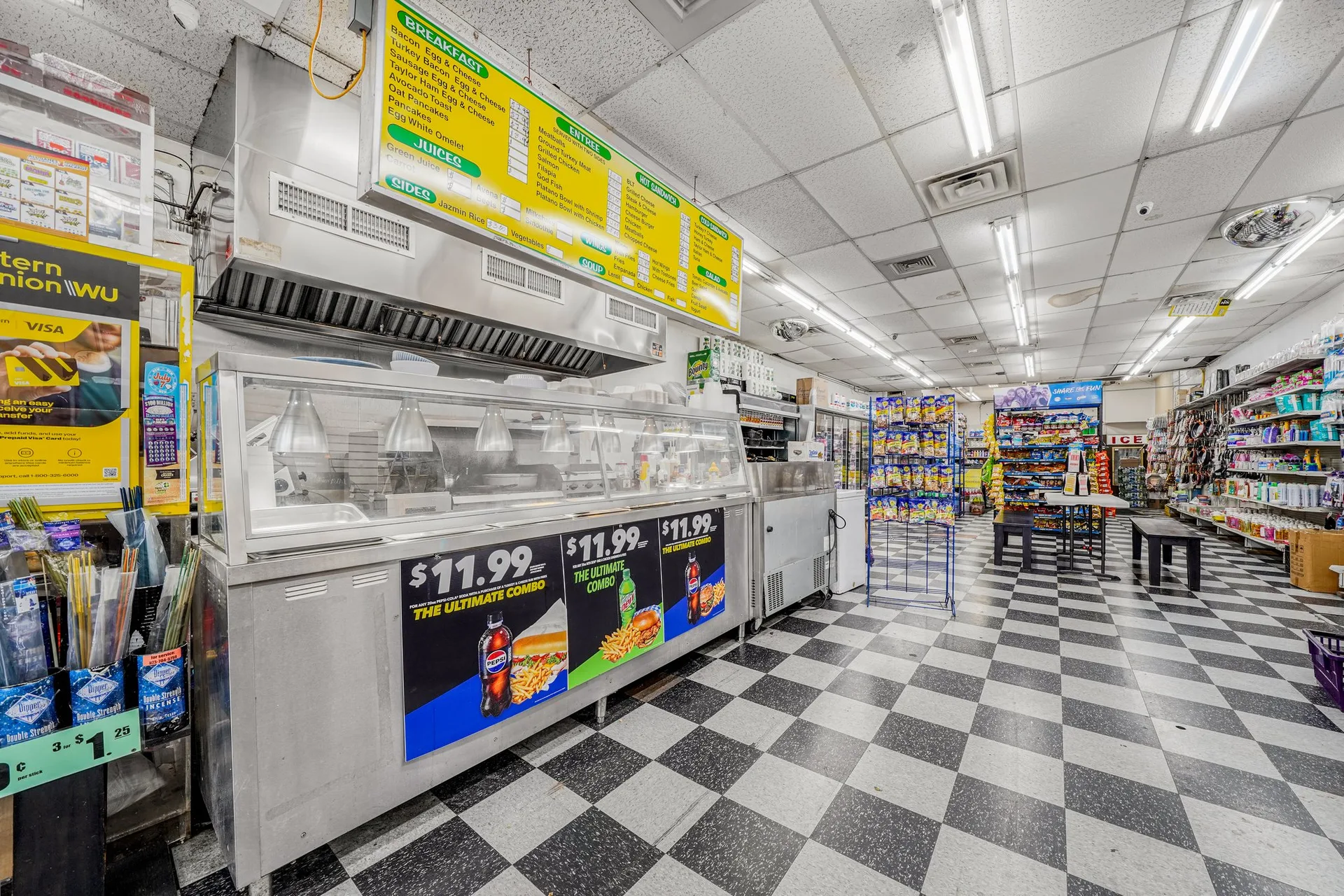Deli counter area with stainless steel equipment, digital menu board, and commercial range hood