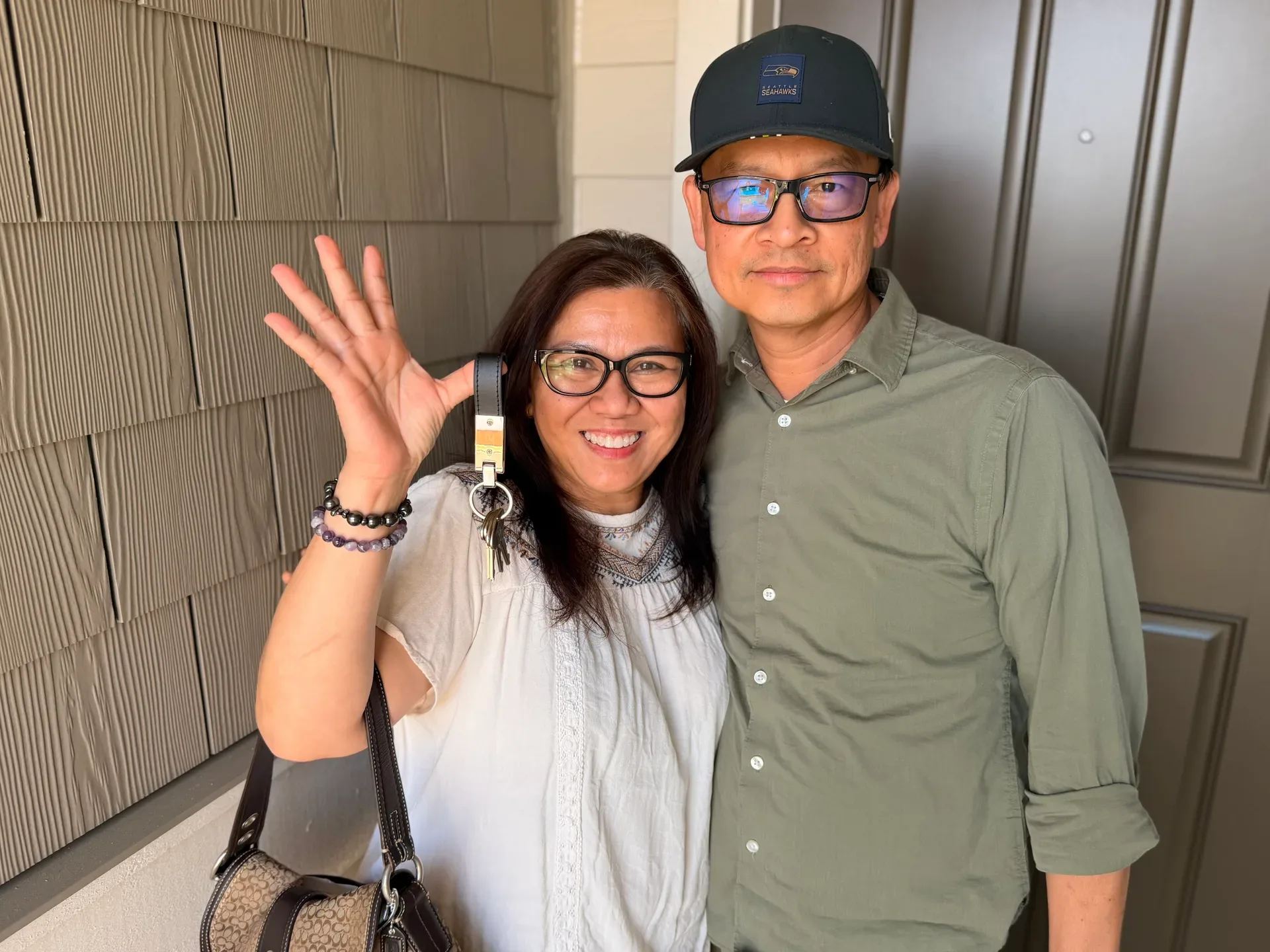 Ray and Nancy at the front door of their new Eastside home, keys in hand