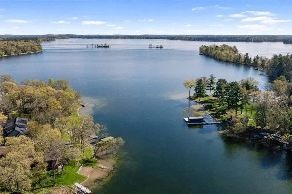Aerial drone view over the lake with dense trees and a boat dock