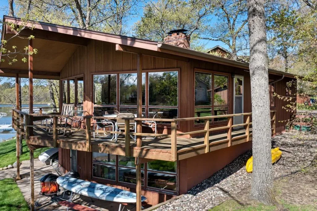 Exterior view of the rustic lakefront cabin with wrap-around deck overlooking the water