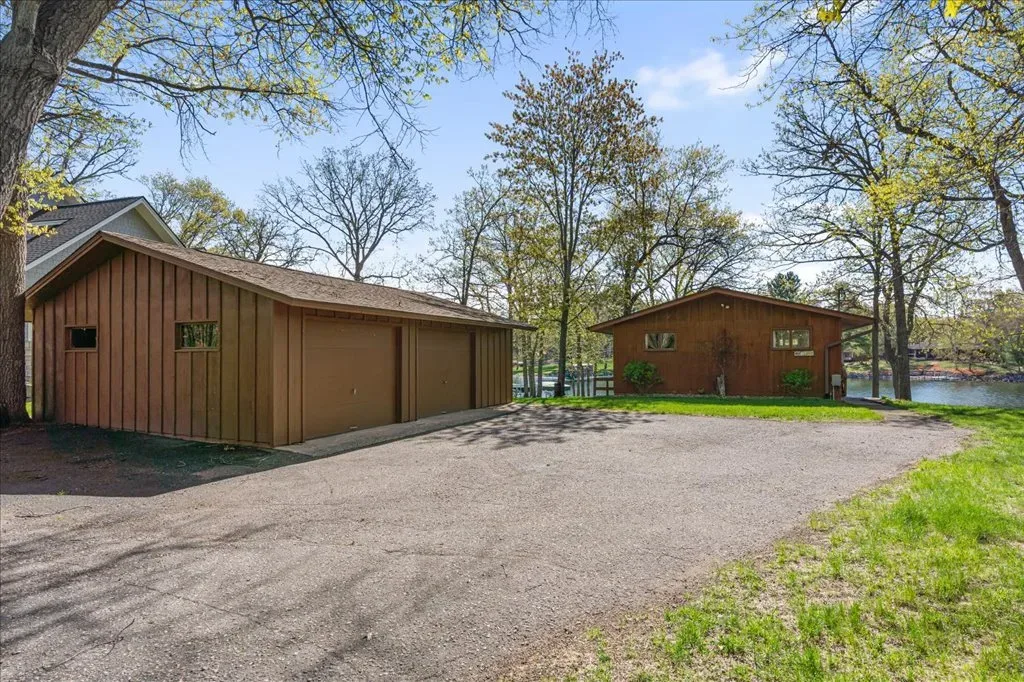 Detached garage and adjacent building with paved driveway