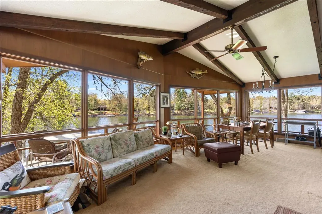 Sunroom with floor-to-ceiling windows overlooking the lake