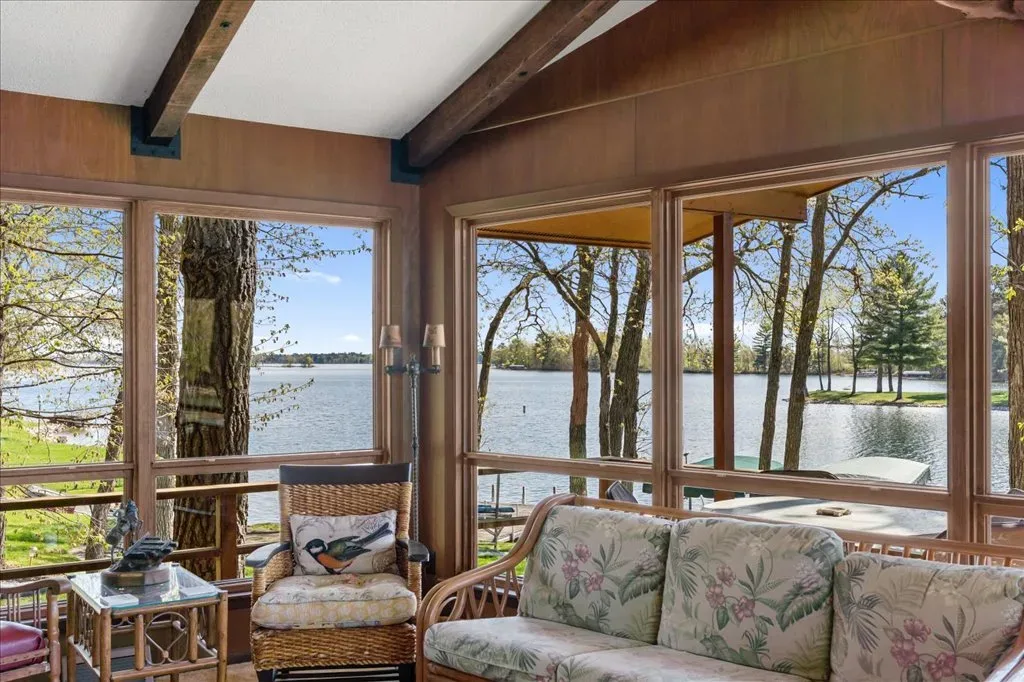 Sunroom or enclosed porch with floor-to-ceiling windows and lake view