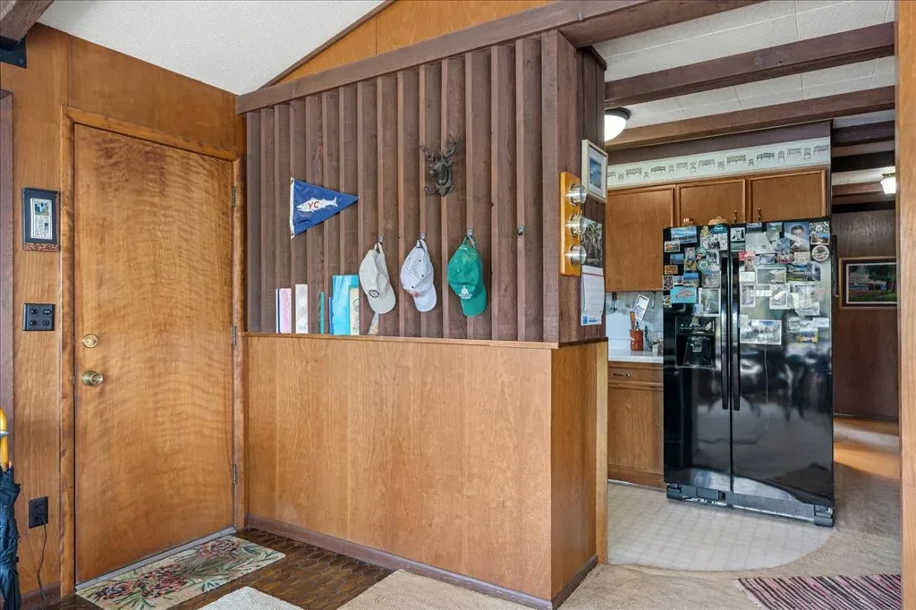 Entry and transition area looking toward the kitchen with wood-slat partition