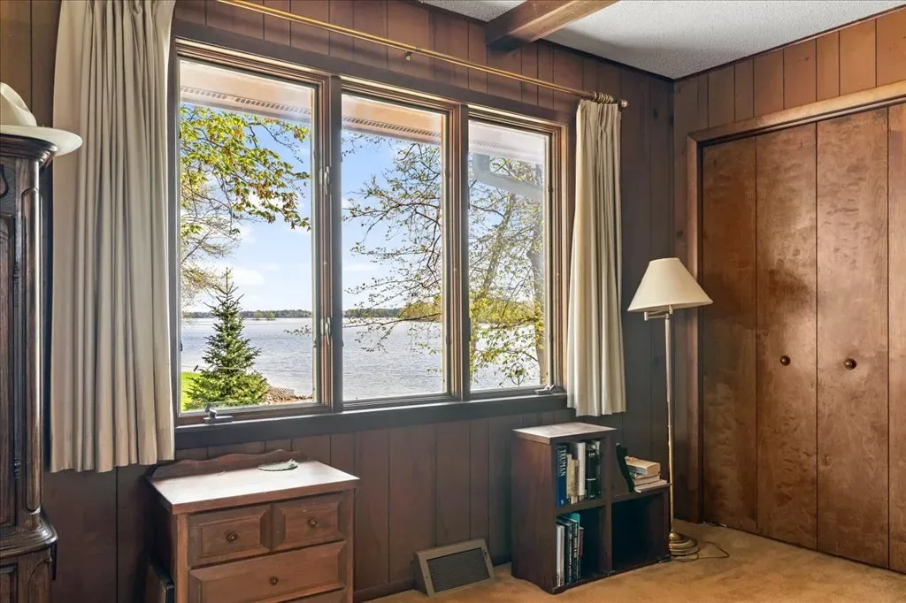Bedroom interior with wood paneling and window view