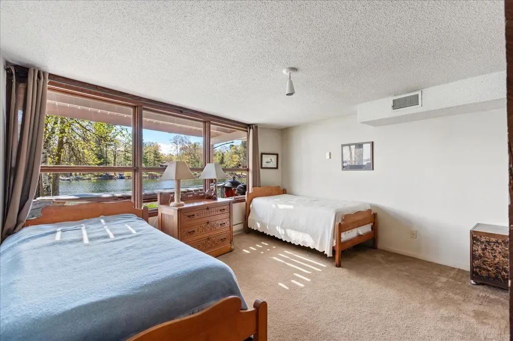 Bedroom with two beds and large lake-facing windows