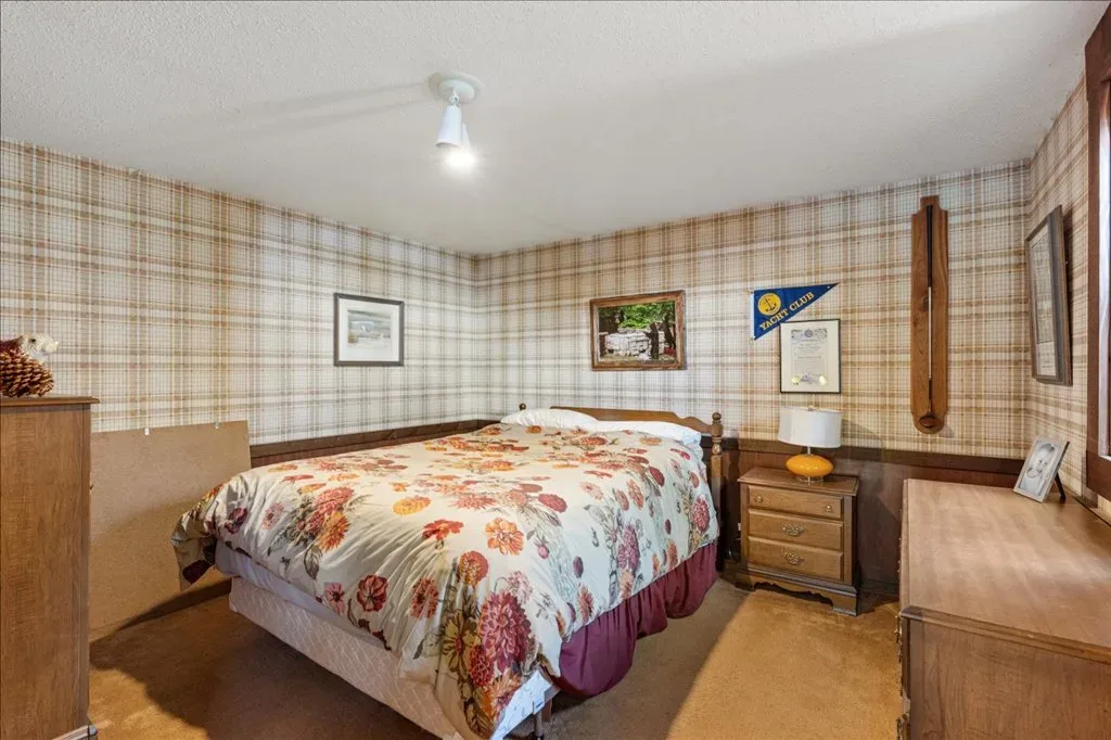 Guest bedroom with plaid wallpaper and wood wainscoting