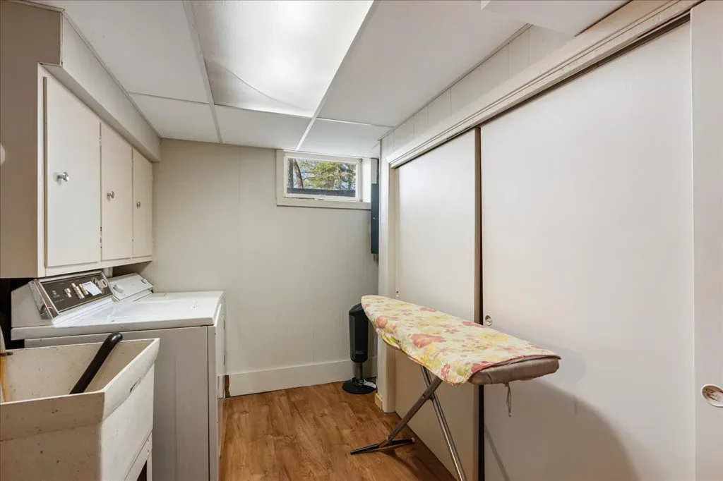 Laundry room with painted wood cabinets and vinyl flooring