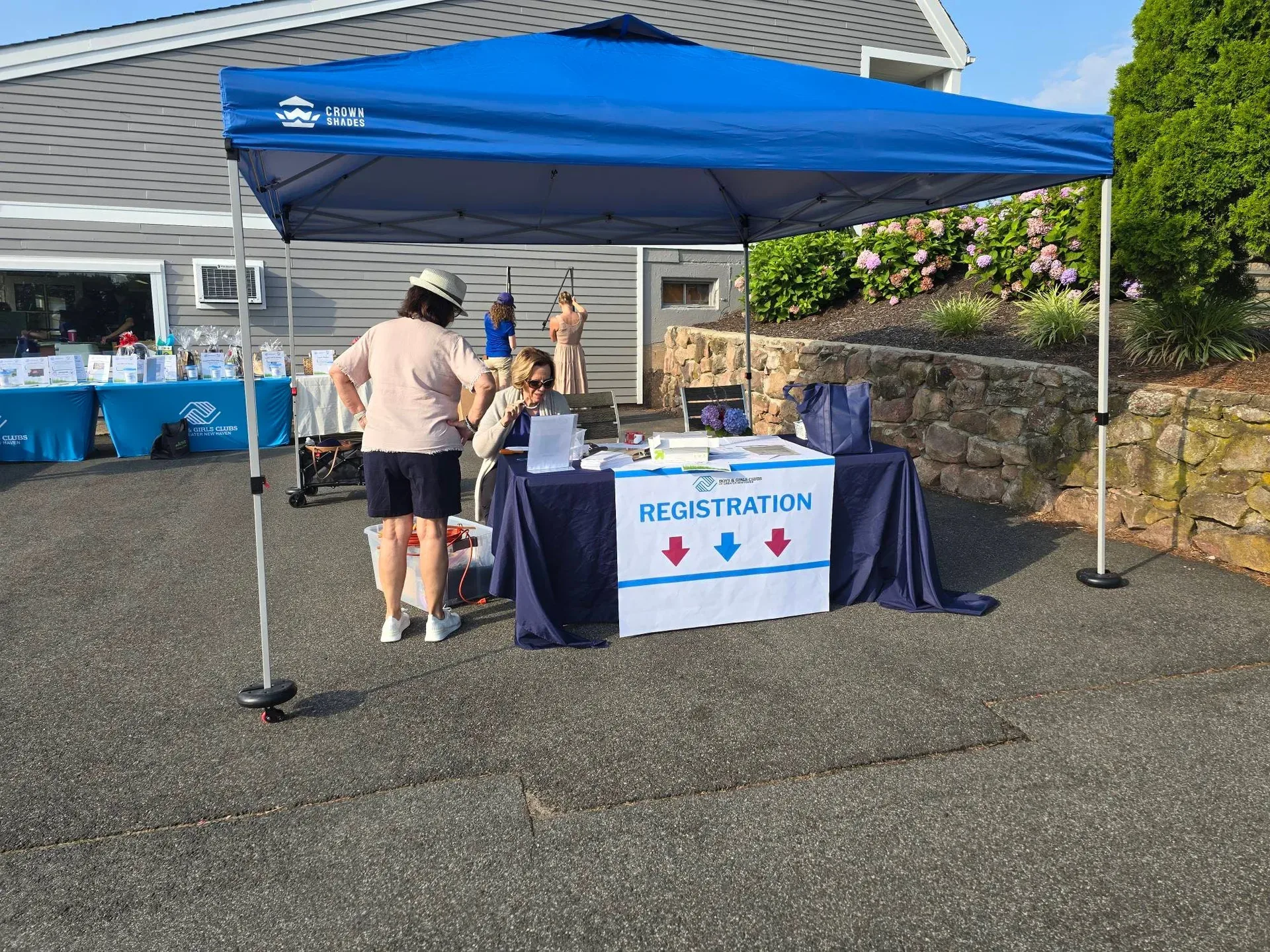 Volunteers and staff prepare the registration area before golfers arrive at the Calcagni Golf Classic