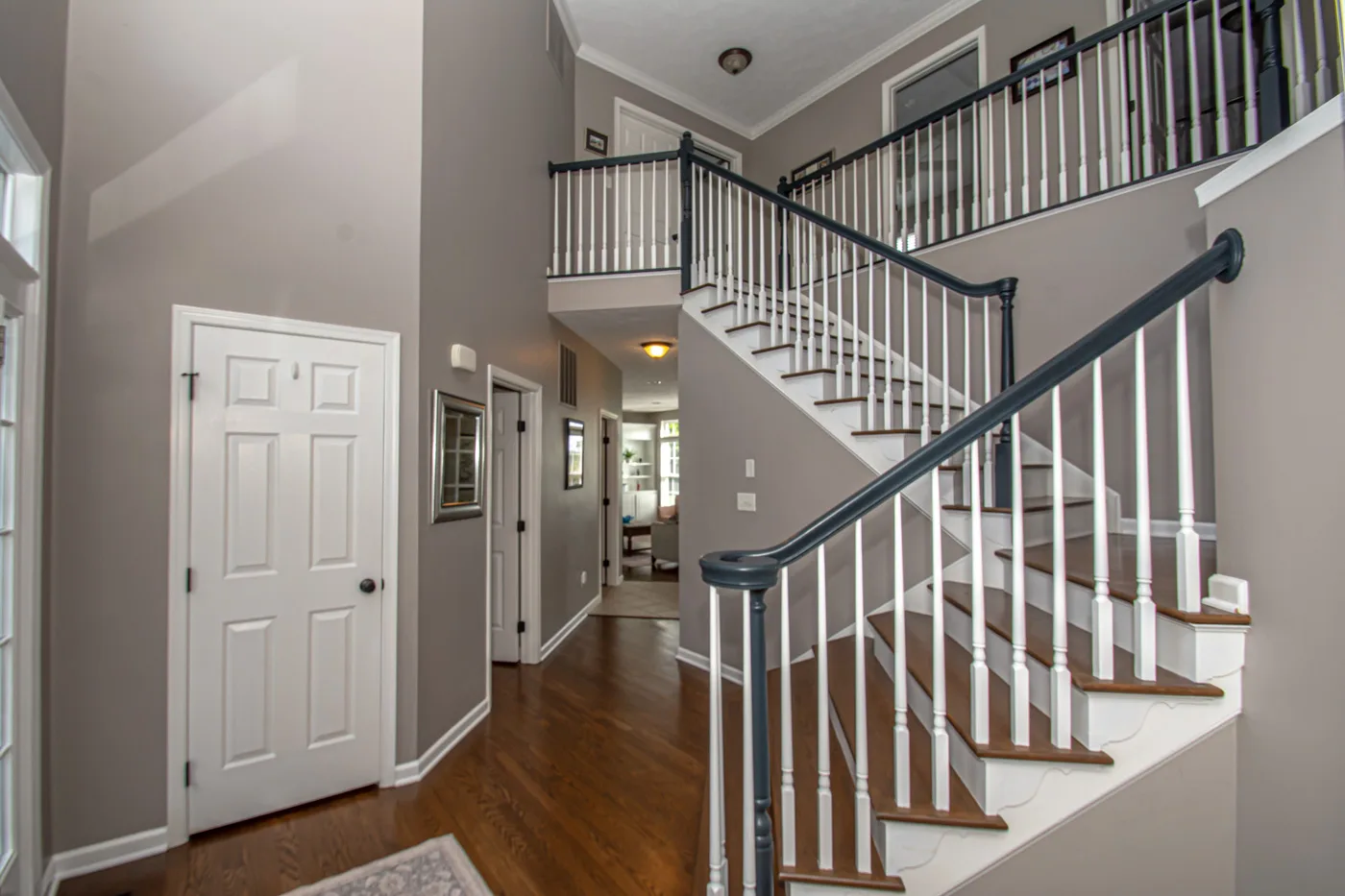 Soaring two-story foyer with new luxury vinyl plank flooring and staircase