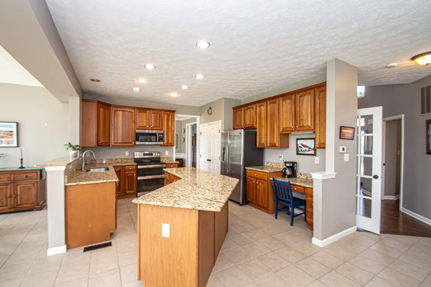 Kitchen with huge center island, granite countertops, and pull-out shelving
