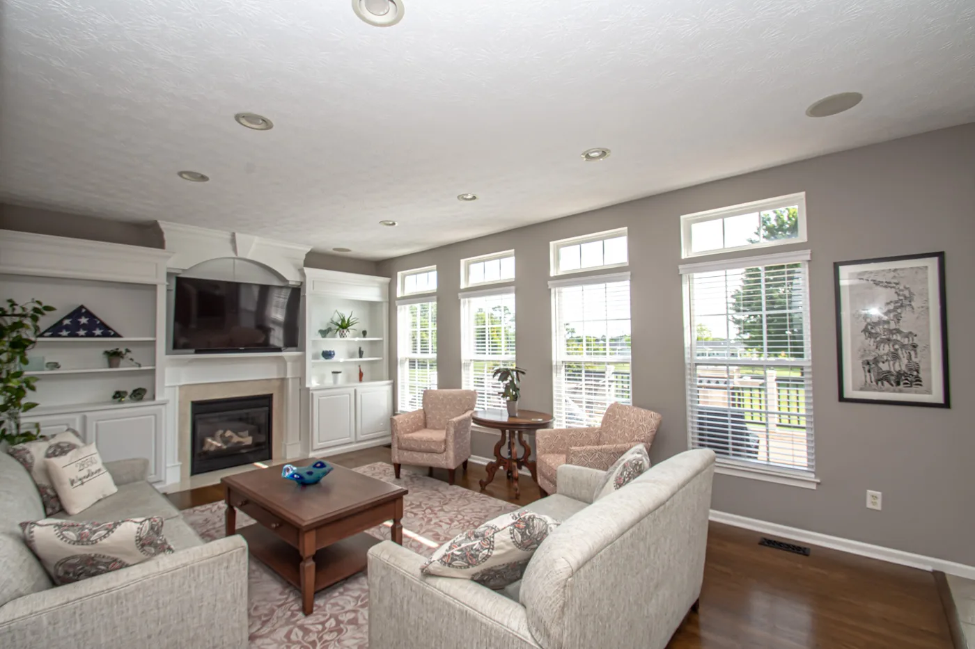 Family room with gas fireplace, custom built-ins, and natural light
