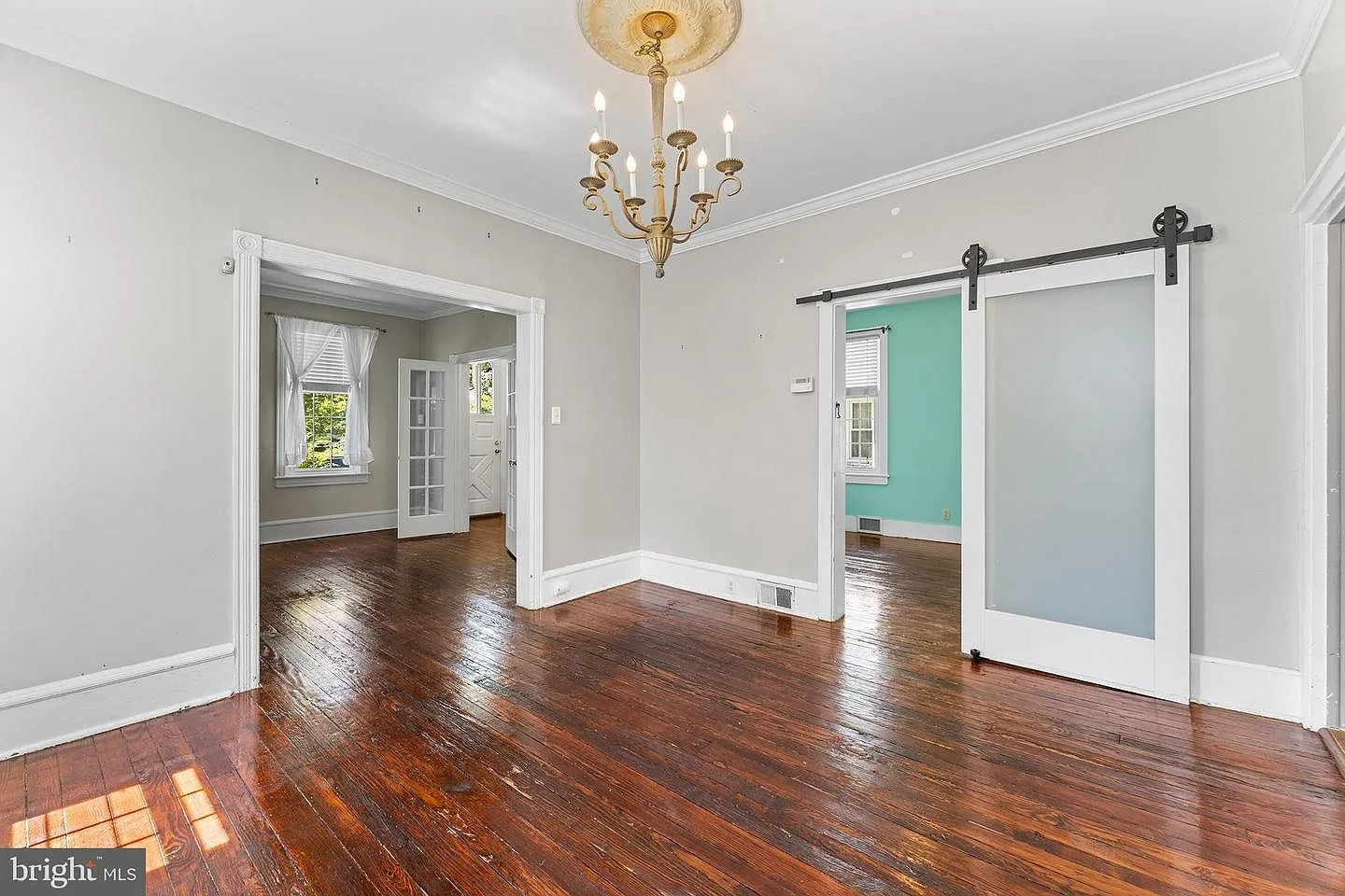 Living room with sliding barn door and decorative chandelier