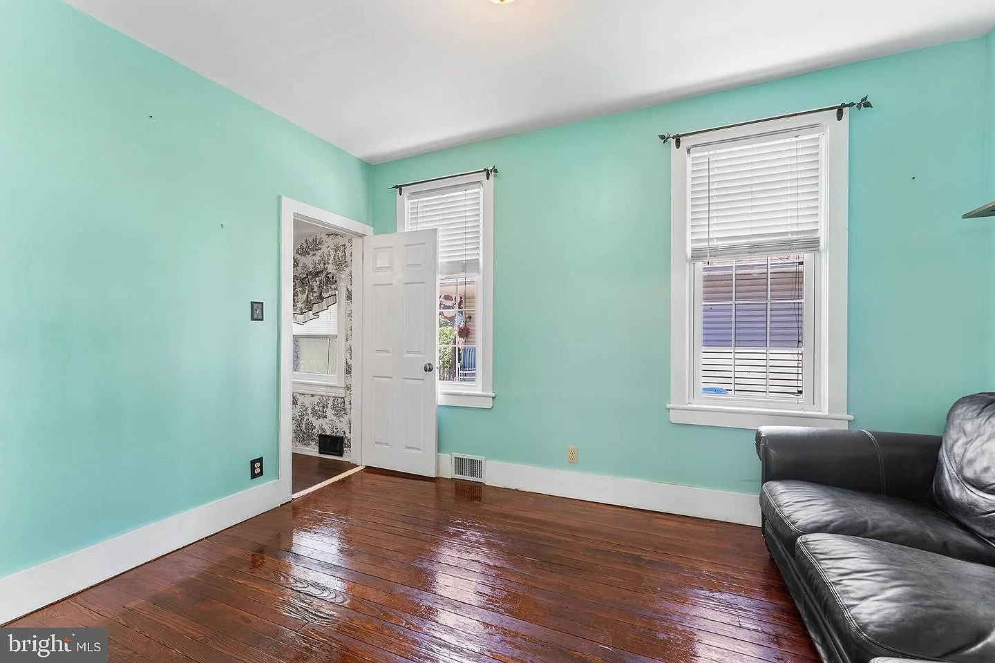 Bedroom with teal walls and wide-plank hardwood floors