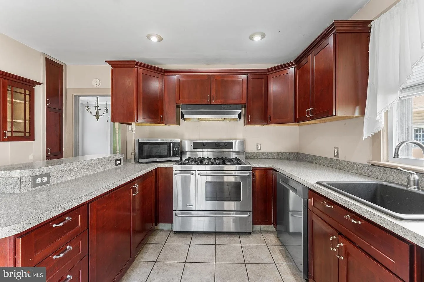 Kitchen view with dark stained cabinets and stone countertops